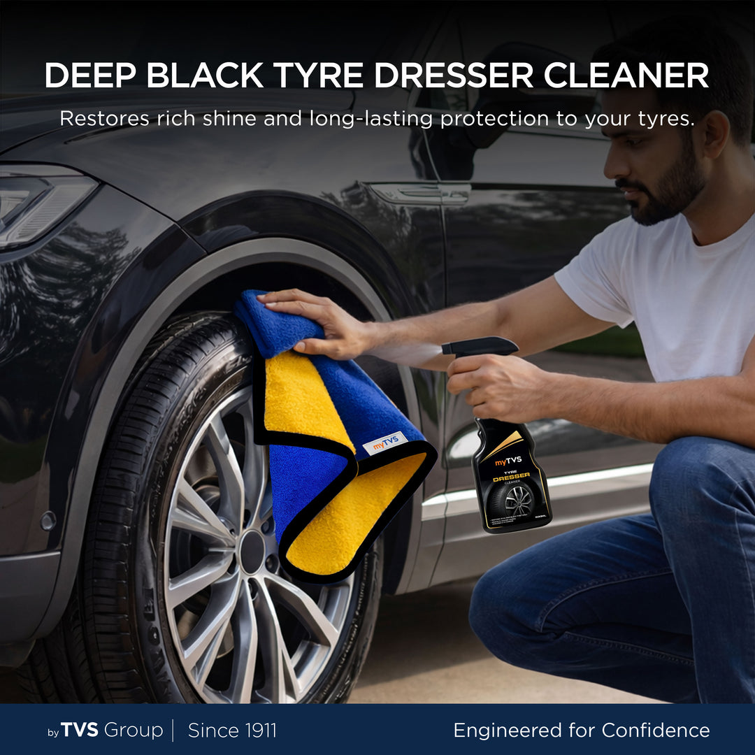 myTVS Deep Black Tyre Dresser Cleaner spray being used with a microfiber cloth to clean and shine a car tyre